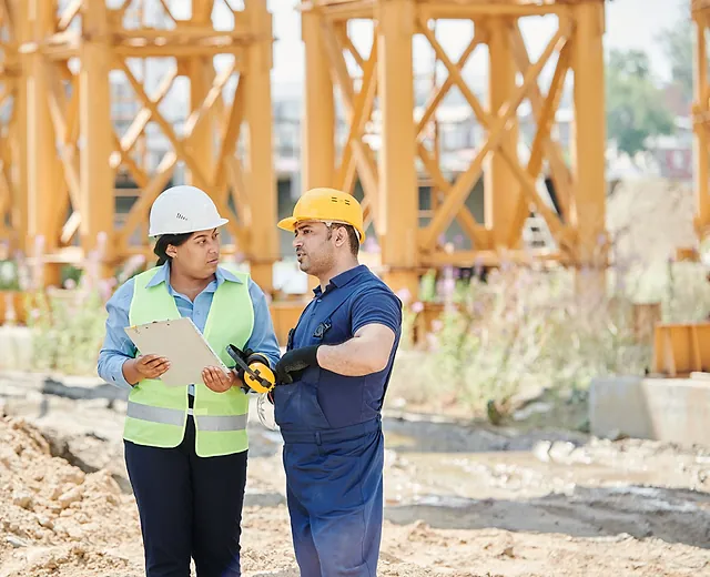 Two engineers in hard hats on site