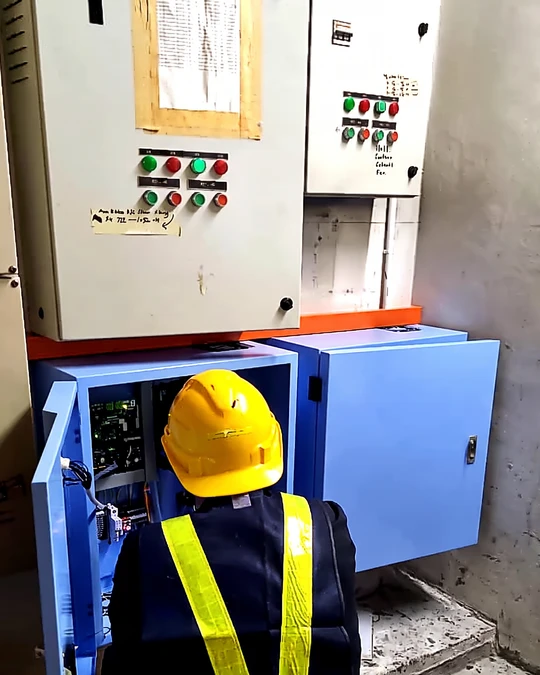 Engineer working at an open DVDC cabinet in a hospital plant room