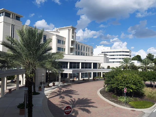 Hospital campus entrance with clinical buildings and landscaped grounds