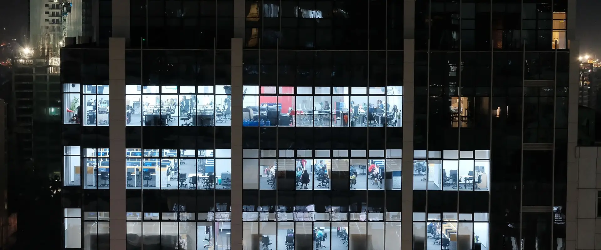 Illuminated office floors seen through a glass curtain wall