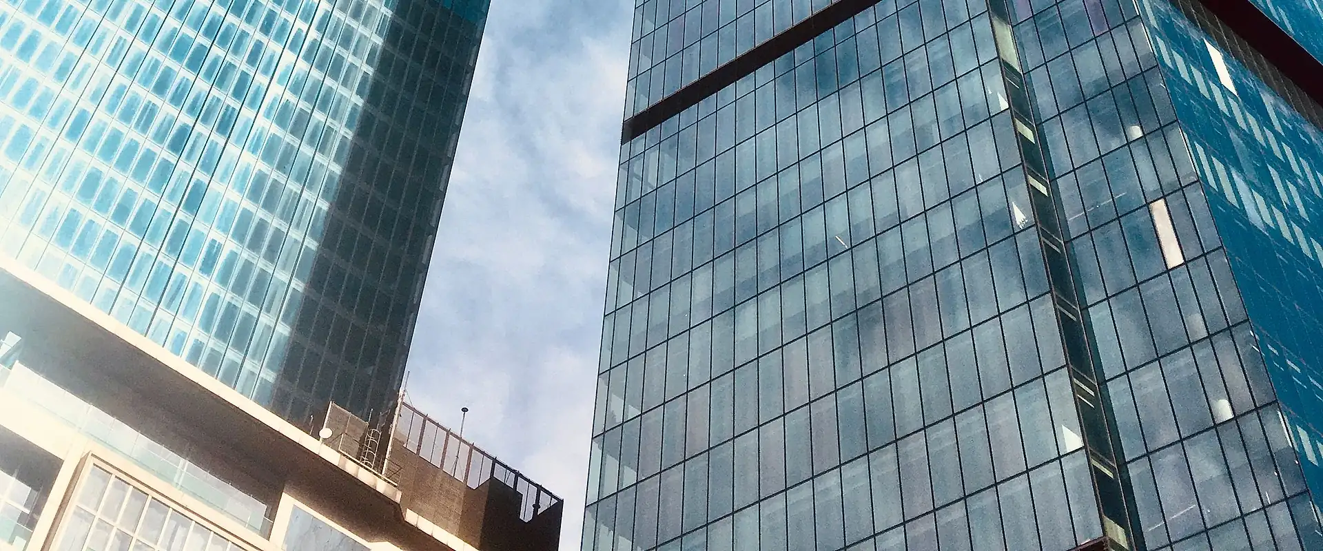 Glass office towers against a blue sky